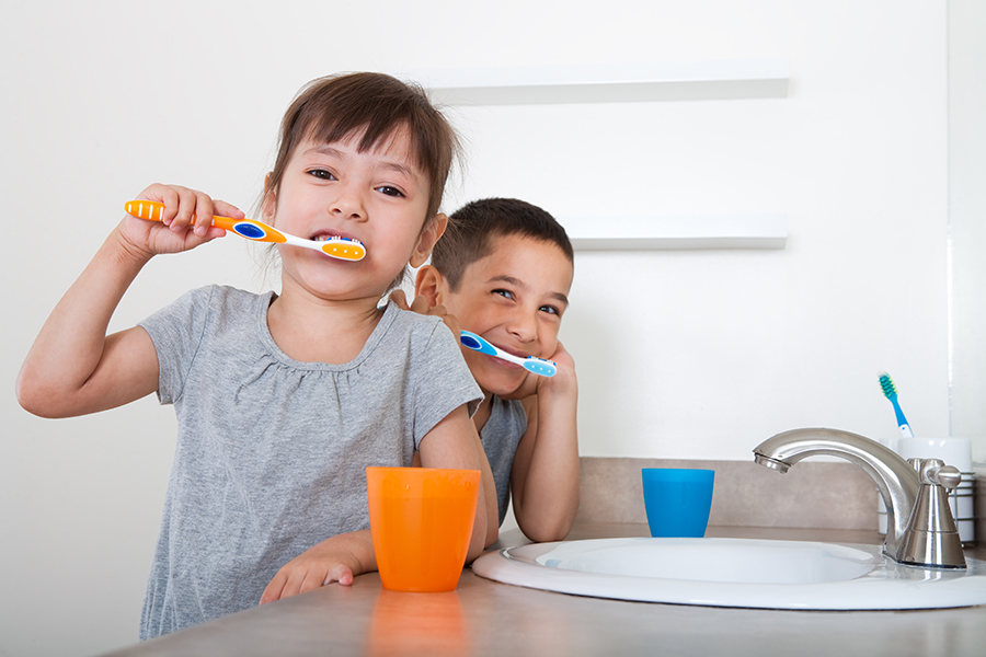 Boy and girl brushing their teeth